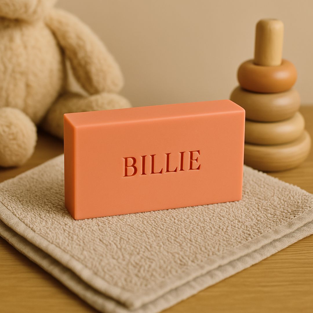 Oranje hotelzeepje op een beige doekje. Op de achtergrond een houten speelgoed en knuffel.