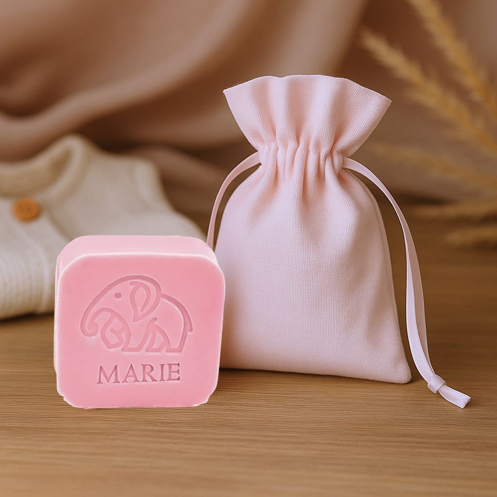 Vierkant zeepje met opdruk olifant en naam naast een stoffen doopsuikerzakje