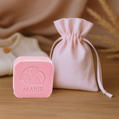 Vierkant zeepje met opdruk olifant en naam naast een stoffen doopsuikerzakje
