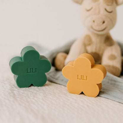 Twee gepersonaliseerde zeepjes in bloemvorm met op de ahtergrond een girafje.