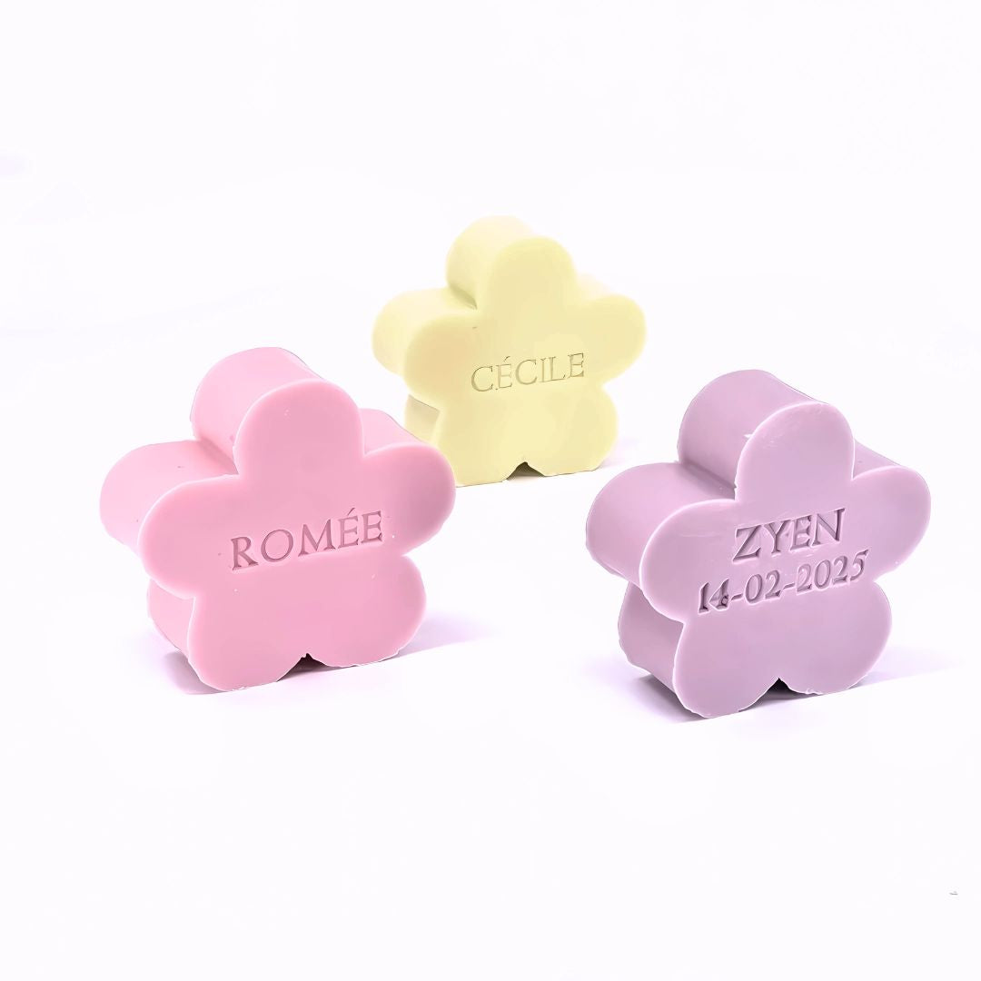 Drie zeepjes met naam in bloemvorm in de kleuren mimosa, rozen en violet.