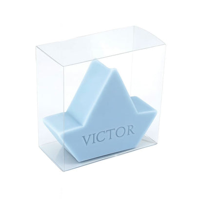 Lichtblauw zeepje in de vorm van een bootje bedrukt met de naam VICTOR verpakt in een transparant doosje.