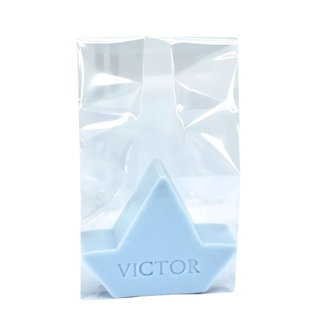 Lichtblauw zeepje in de vorm van een bootje bedrukt met de naam VICTOR verpakt in een transparant zakje.