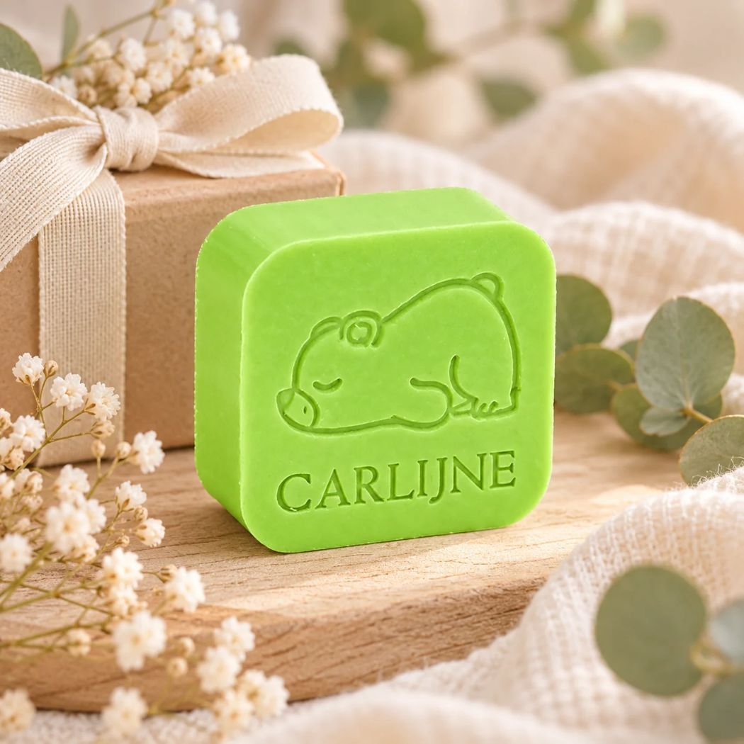 Gepersonaliseerd vierkant zeepje met slapend beertje en de naam Carlijne in kleur Appel, sfeervol gepresenteerd met eucalyptus, droogbloemen en een cadeaudoosje.