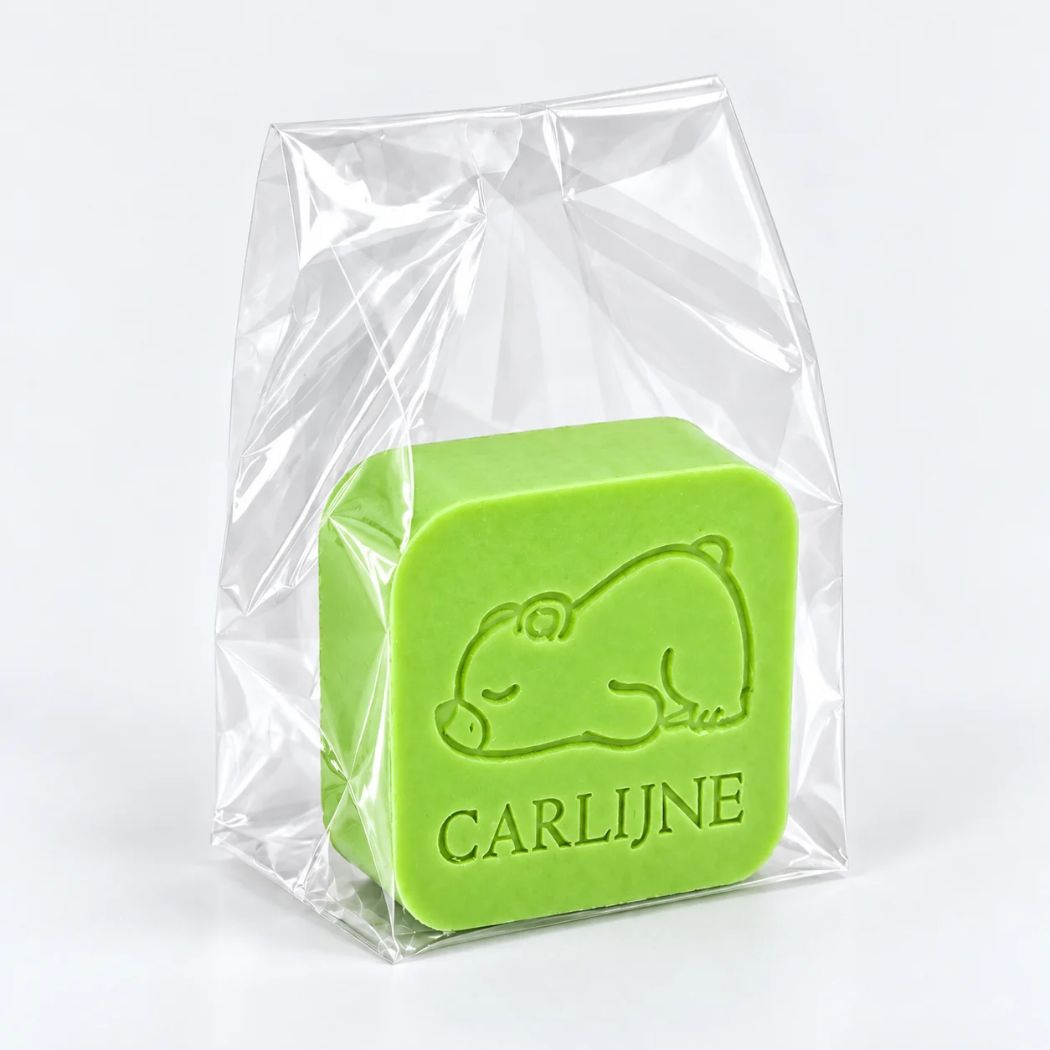Gepersonaliseerd vierkant zeepje met slapend beertje en de naam Carlijne in kleur Appel, verpakt in een transparant zakje.