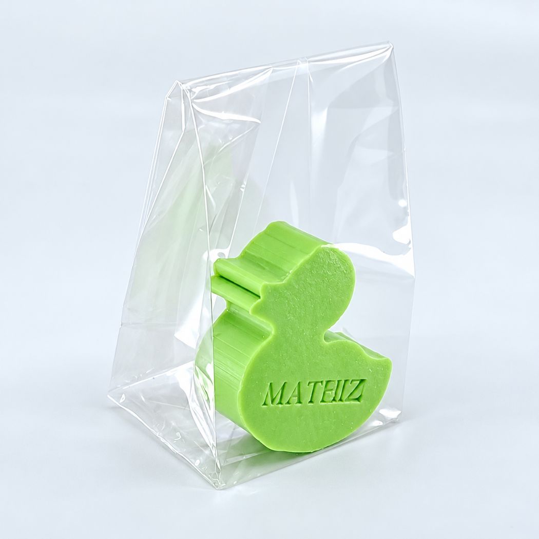 Gepersonaliseerd eendvormig zeepje met de naam Mateiz in de kleur appel, verpakt in een transparant zakje op een lichte achtergrond.