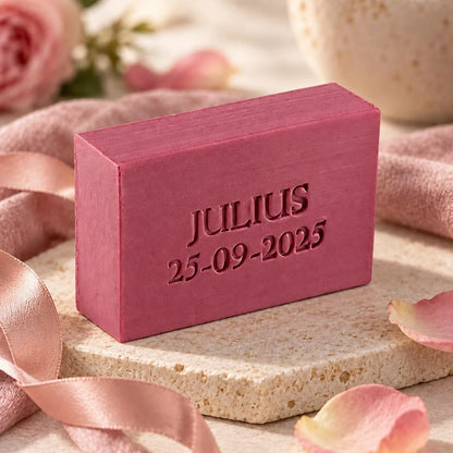 Bordokleurig rechthoekig zeepje, model Mini Retro, met de naam Julius en datum 25-09-2025. Sfeervol gepresenteerd met roze lint en rozenblaadjes.