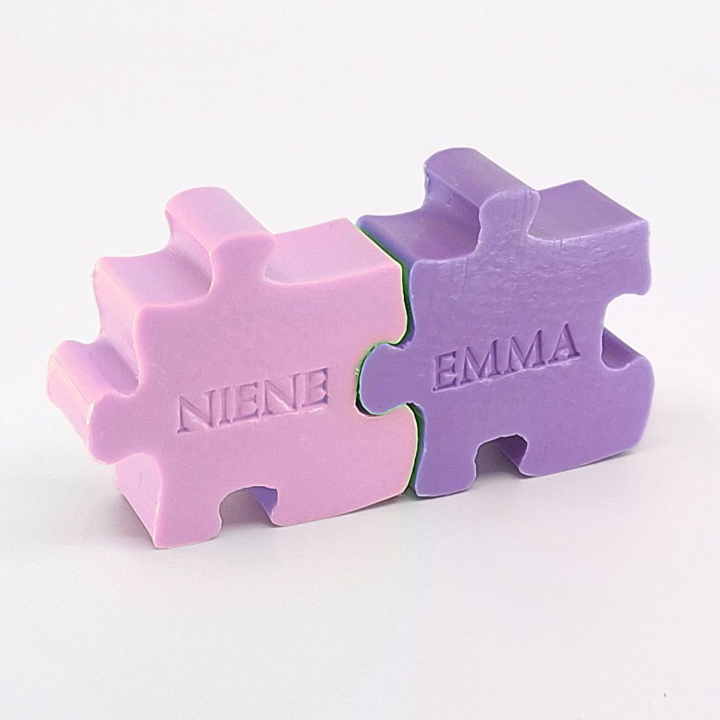 Twee gepersonaliseerde zeepjes met naam in de vorm van een puzzelstuk in kleuren Violet en Lavendel.