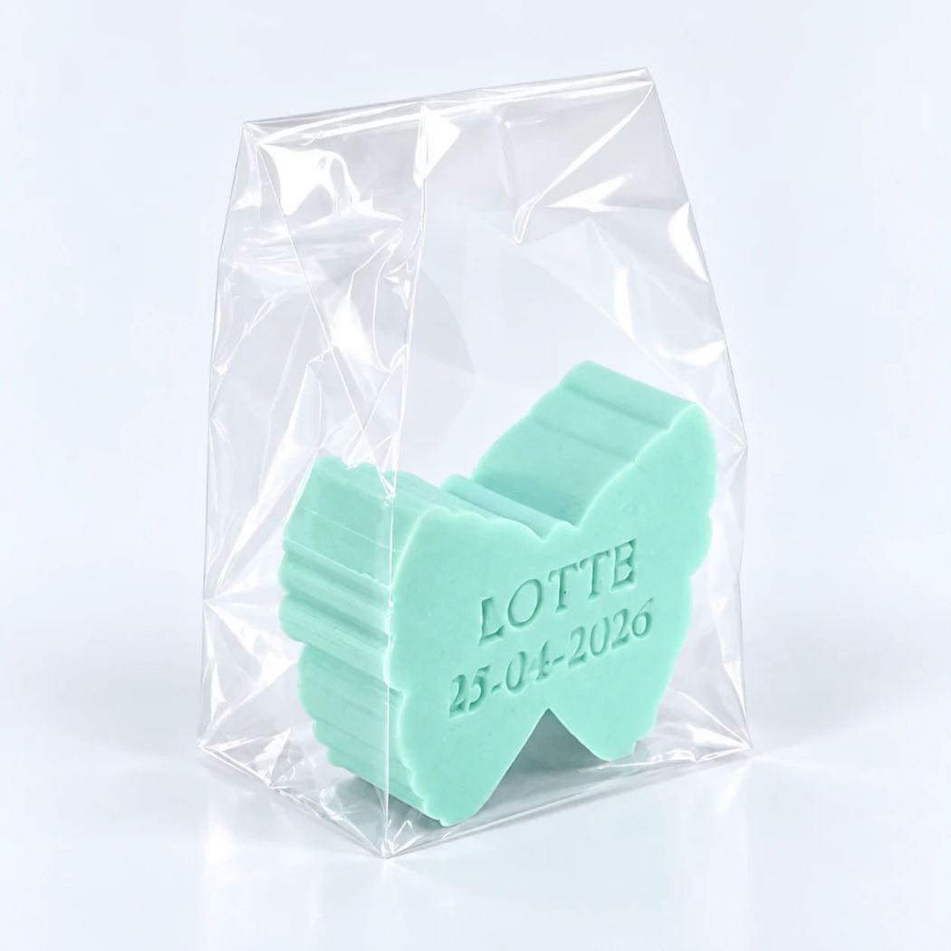 Muntgroen vlinderzeepje met naam Lotte en datum 25-04-2026 in een transparant geschenkzakje op een lichte achtergrond.
