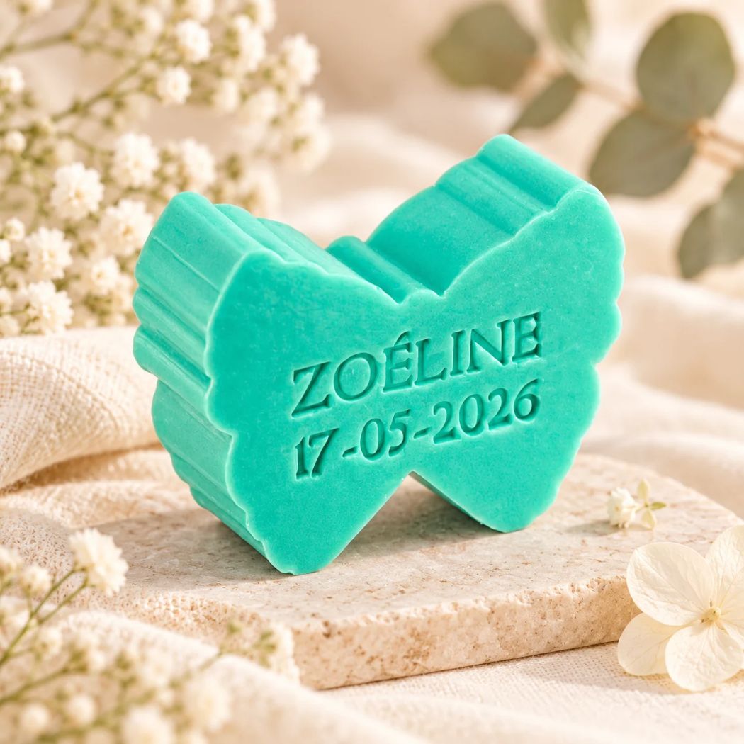 Gepersonaliseerd zeepje in de vorm van een vlinder met de naam Zoëline en datum 17-05-2026, in de kleur zeealgen, sfeervol gepresenteerd in een zachte neutrale setting.