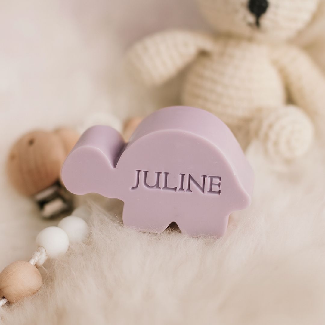 Een gepzersonaliseerd schildpad zeepe in klur lila op een schaapvel.