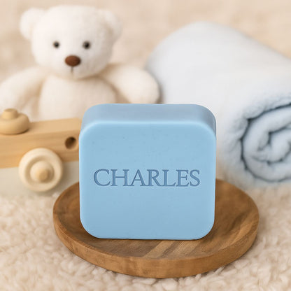Lichtblauw vierkant zeepje met naam "CHARLES" in een babysetting.
