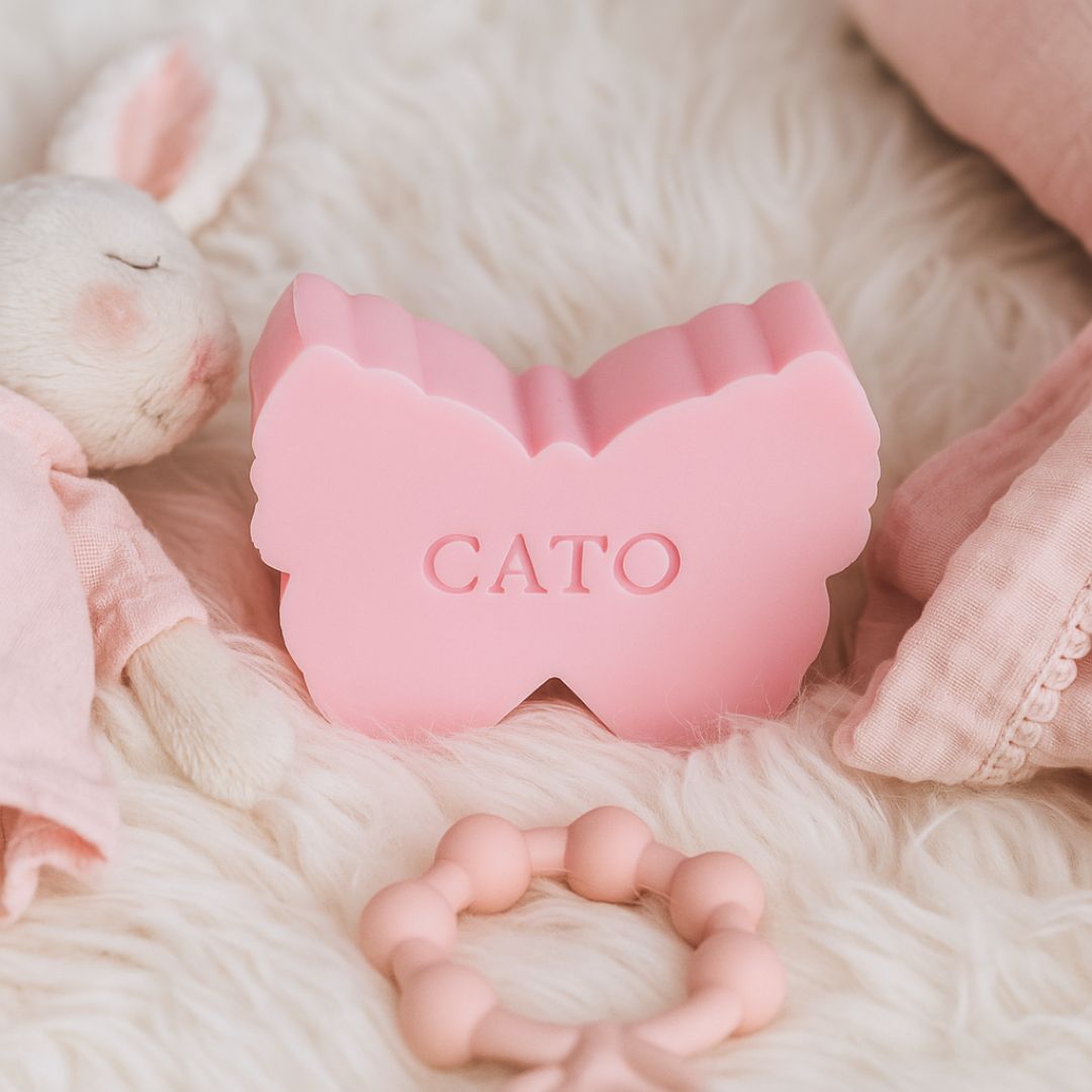 Roze vlinderzeepje met naam CATO op zachte babysetting met knuffelkonijn.