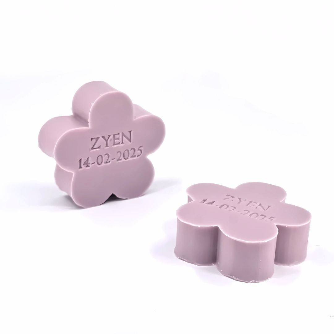 Twee gepersonaliseerde lila zeepjes in bloemvorm met opdruk van naam en datum