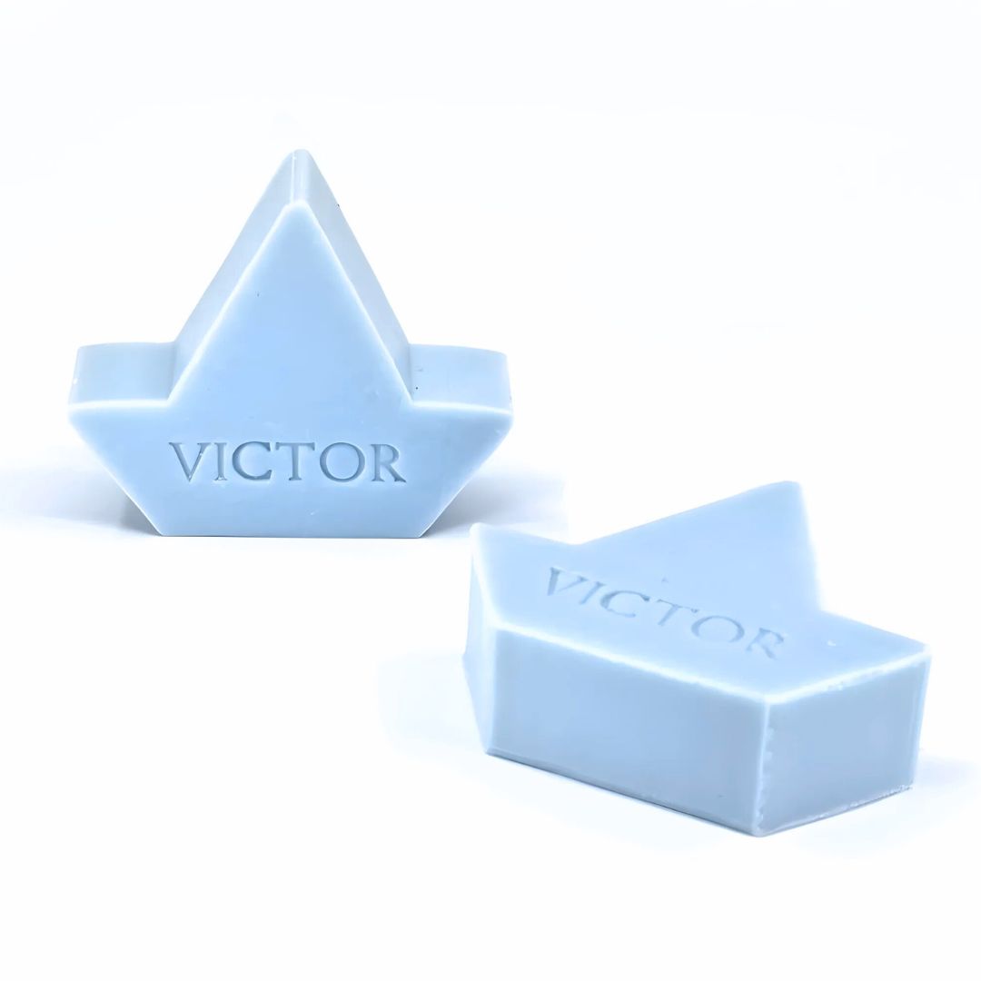 Twee lichtblauwe zeepjes in de vorm van een bootje bedrukt met de naam VICTOR.