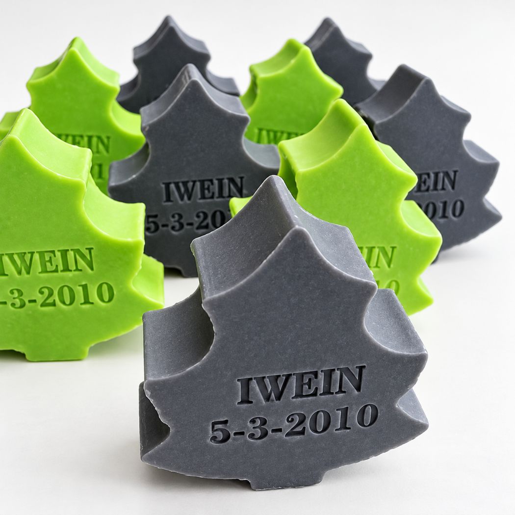 Gepersonaliseerde kerstboomzeepjes met de naam Iwein en datum 5-3-2010, in de kleuren appel en opium, samen gepresenteerd op een lichte achtergrond.